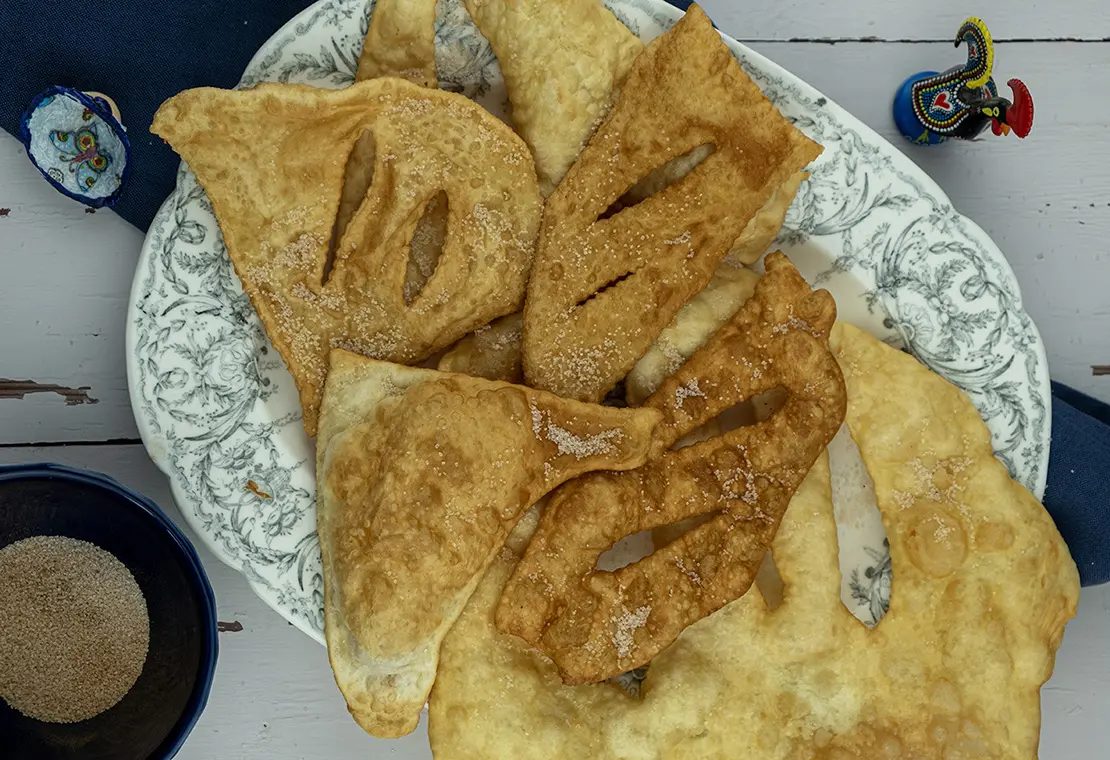 |Nu gaan we het geheel kneden met de hand.|Zodra je massa niet meer plak is het tijd voor de volgende stap.|Leg je mengsel op een plank die je van tevoren hebt bestrooid met wat bloem|Snijdt de massa in stukjes en kneedt weer|Herhaal dit enkele keren.|Snijdt nu stukjes van het mengsel en iedere stukje rol je met een deegroller.|Verhit een koekenpan met zonnebloemolie.|Coscorões: Leg daar een voor een de plakjes in voor een paar minuutjes|coscorões: Keer af en toe.|coscorões : Als de plakjes een kleurtje hebben zijn ze klaar.||Palmira en Camiel|Coscorões is een klassieke Portugese zoetigheid