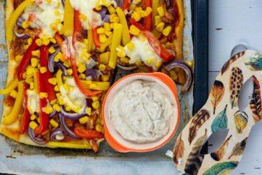 Carnavalspizza met zwarte knoflooksaus